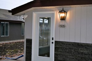 A house with a white door, a stone base, and a number '1505' on the wall. - Studio 7: Charming Studio Apartment Near Riverside Park in Grand Forks, ND (Grand Forks)
