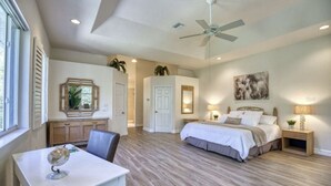 A bedroom with a bed, bedside tables, a desk with a globe, and a ceiling fan. - Waterfront Oasis and Boaters Paradise! Coastal style home with Boat Dock! 🚤🎣 (Englewood)