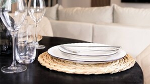 Una mesa para comer con un mantel tejido, un plato blanco y un tenedor y cuchillo de plata.