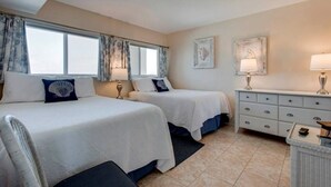 Une chambre d’hôtel avec deux lits, une commode et une fenêtre avec des rideaux.