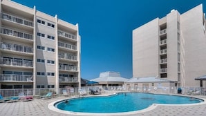 Une piscine entourée d’un bâtiment doté de nombreux balcons.