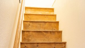 A wooden staircase with a handrail, leading to an upper floor. - Located on the river, facing the Mountains (Red River)