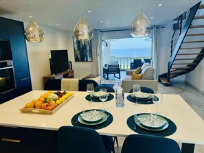 A modern dining area with a table set for two, a fruit tray, and a view of the outdoors. - Rendez-vous à St-Martin - Balcon sur le Bleu (Marigot)