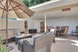 Un patio al aire libre con mobiliario de mimbre, una mesa con un vaso, y un letrero que dice "The Vermilyea's".