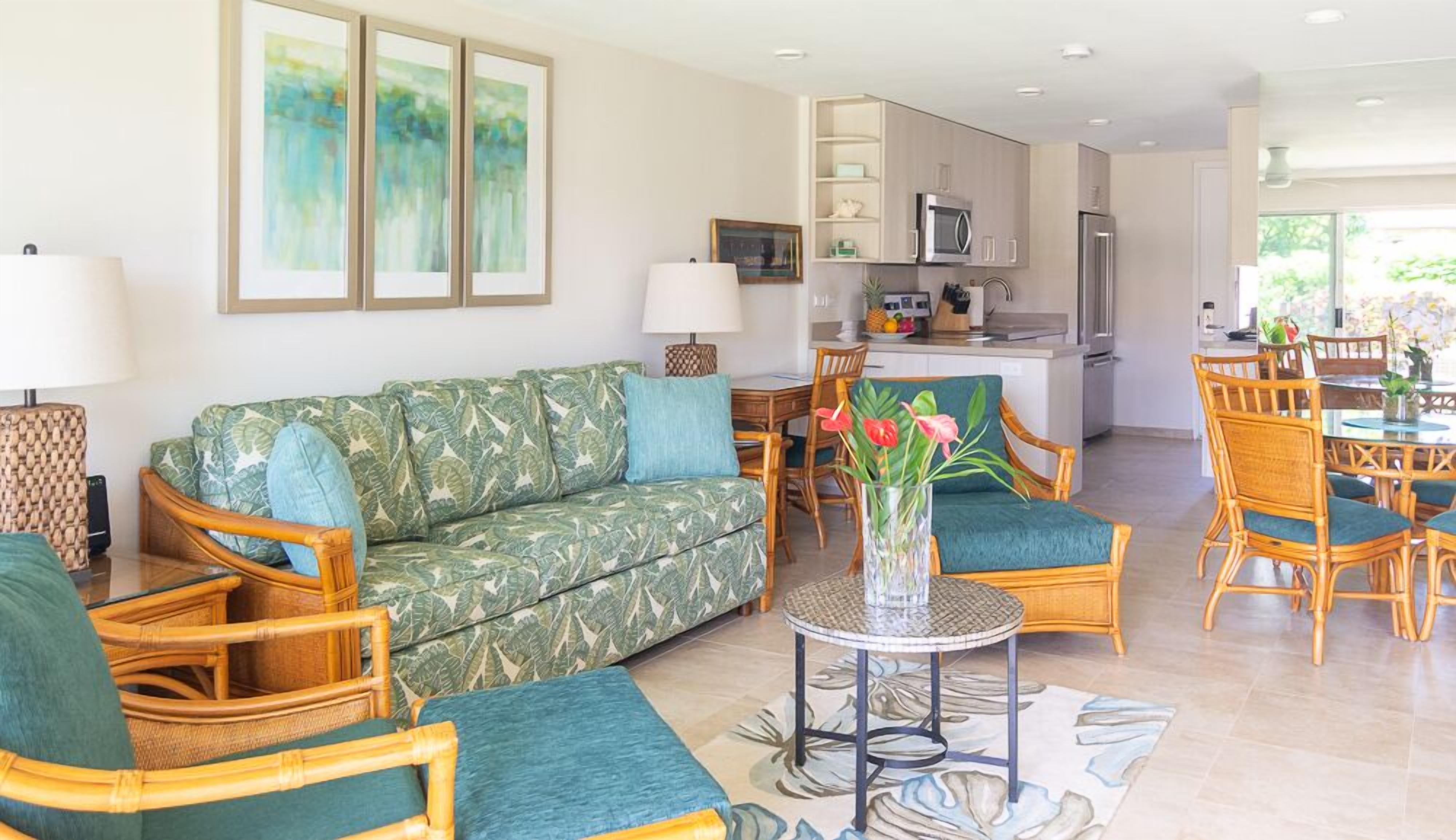 A modern living room with a sofa, chairs, a coffee table, and artwork on the wall.