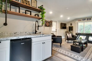 Enjoy a homey atmosphere in this living space with a kitchen, dining area, and comfortable seating.