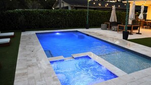 A rectangular swimming pool with a tiled edge and a small waterfall feature. - BaeCation Dania! Near Fort Lauderdale Airport, beach & casino!
pool & jacuzzi! (Dania Beach)