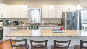 A modern kitchen with white cabinets, a granite countertop, stainless steel appliances, and pendant lighting. - Parkwood Manor at Bear Creek Lakes in Jim Thorpe (Jim Thorpe)
