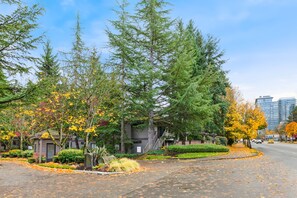 A residential area with trees, a driveway, and a building with a staircase. - NEW Lux Bellevue 2BD 2BA Condo - Free Parking (Bellevue)