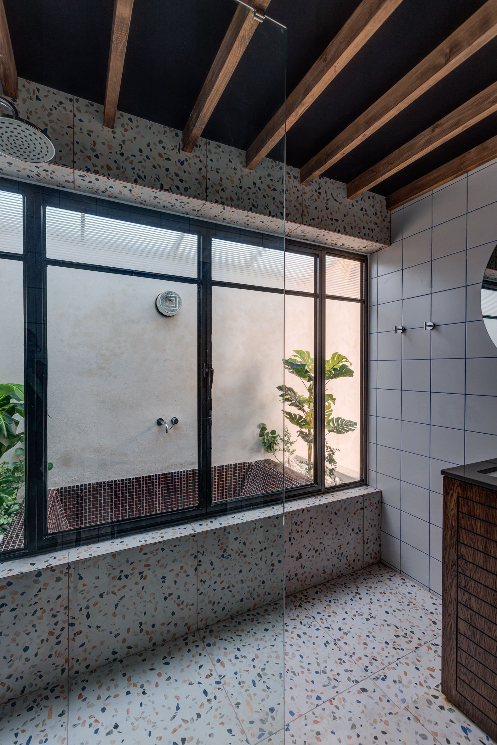 Un baño moderno con ducha independiente, una ventana con vistas a la vegetación y suelo de baldosas.