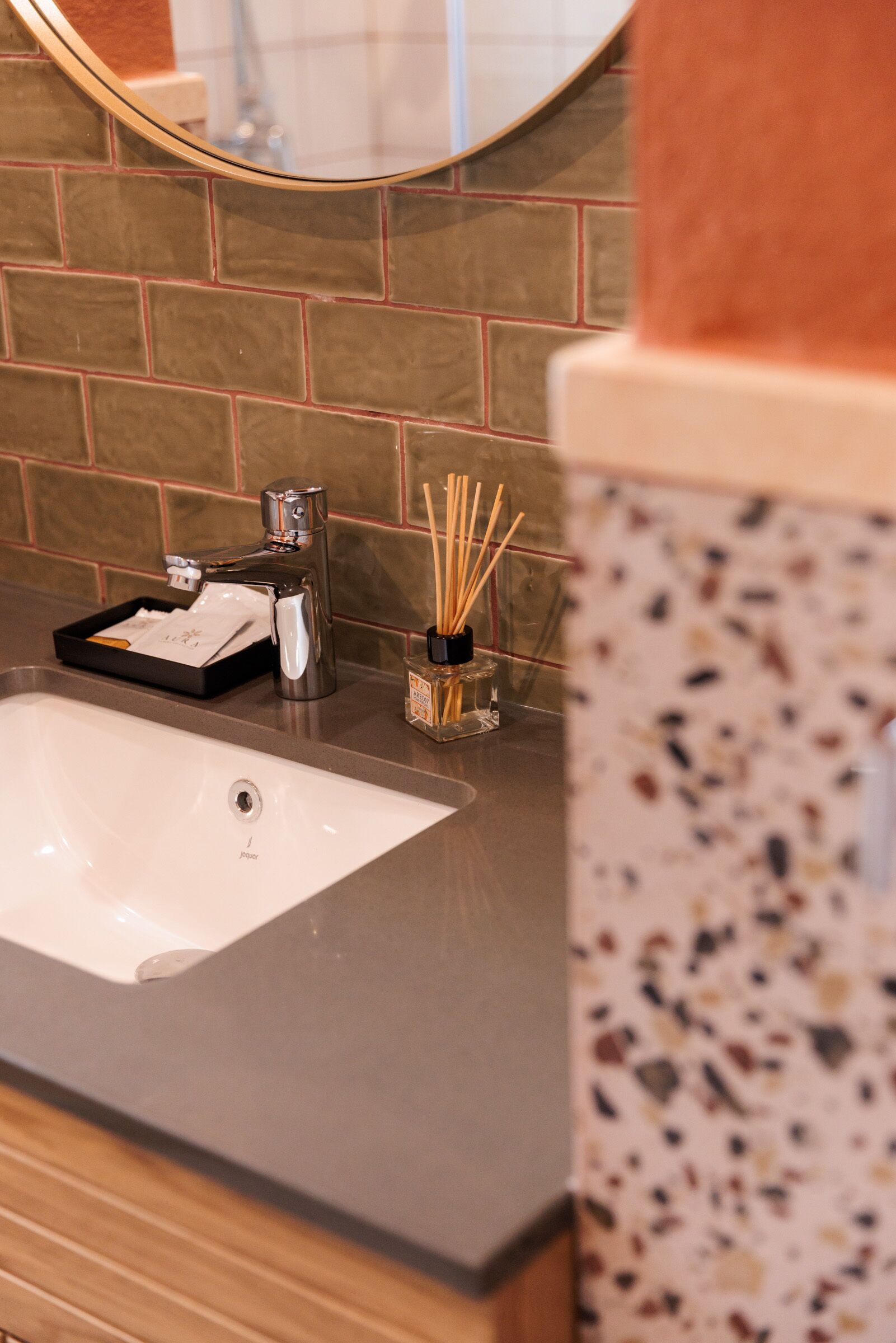 Une salle de bain avec un lavabo blanc, un miroir et un porte-serviettes.