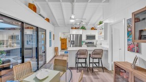 A modern kitchen with white cabinetry, stainless steel appliances, and a central island with bar stools. - Bay Sunsets Free Kayaks/Paddleboard Jacuzzi (Key Largo)