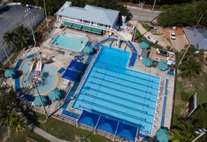 An aerial view of a hotel with multiple swimming pools, a covered area, and a building with a green roof. - Lagoon View Free Kayaks Pool Playground Pickle Ball (Key Largo)