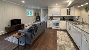 A modern kitchen with white cabinets, a built-in oven, and a microwave.