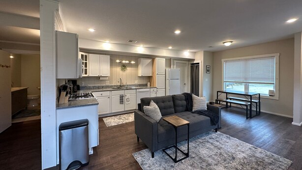 A modern kitchen with white cabinets, a built-in stove, and a refrigerator.