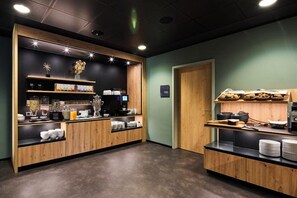 A kitchenette area with wooden cabinets, a coffee machine, and various kitchen utensils. - Top Hotel Rhoenkitz Bad Kissingen (Bad Kissingen)