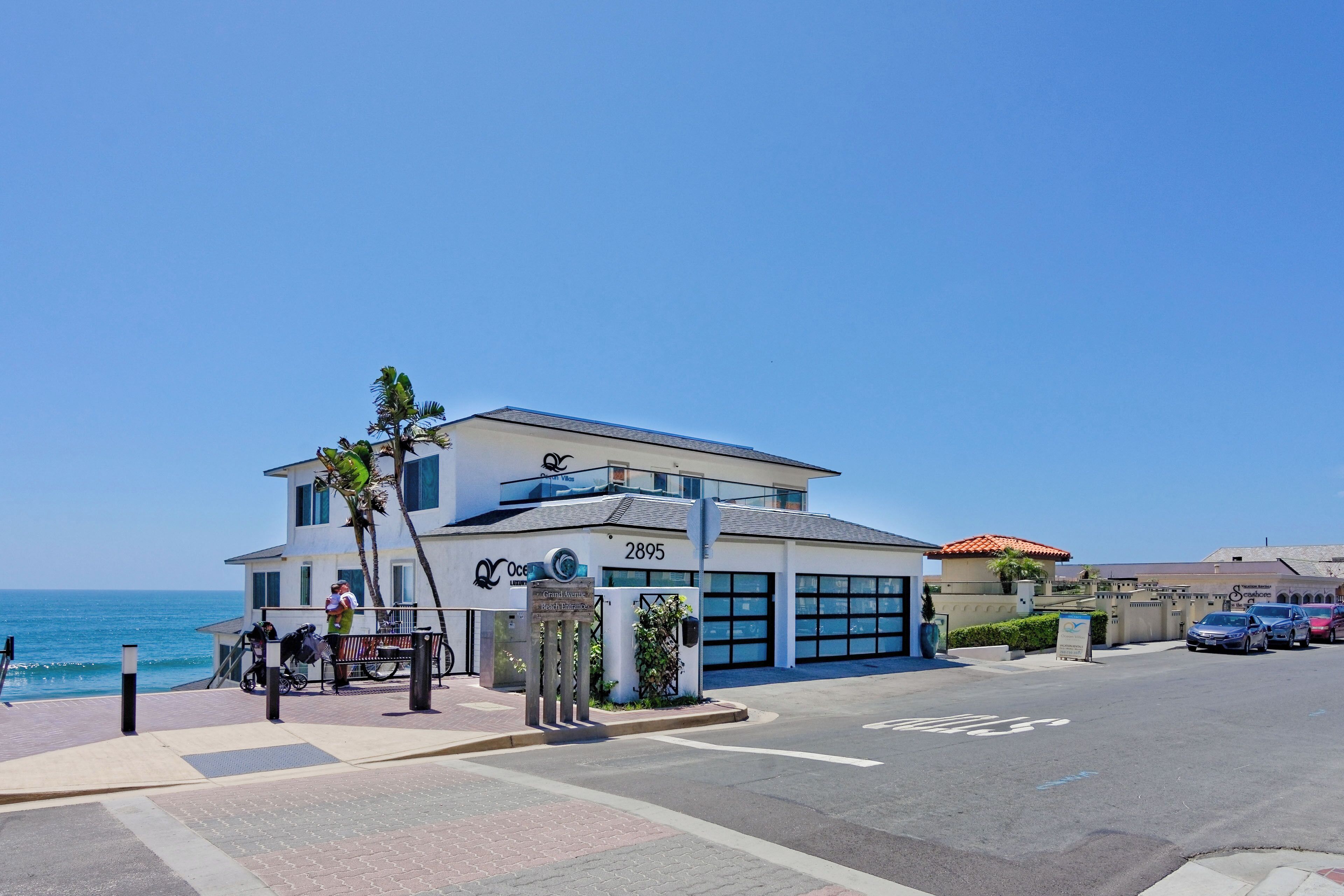 A modern building with a large garage, a sign indicating 'Oceanview,' and a view of the ocean.