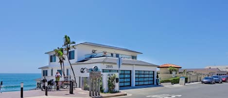 A modern building with a large garage, a sign indicating 'Oceanview,' and a view of the ocean.