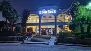 Ein Hotel Eingang mit einem Schild mit der Aufschrift 'Eden Rock' und einer Treppe, die zum Eingang führt.