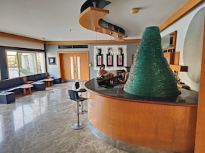 Eine moderne Lobby mit einer gebogenen Rezeption, Sitzgelegenheiten und Kunstwerken an den Wänden.