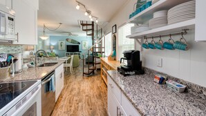 Una cocina moderna con encimeras de granito, horno empotrado y espacio para café.