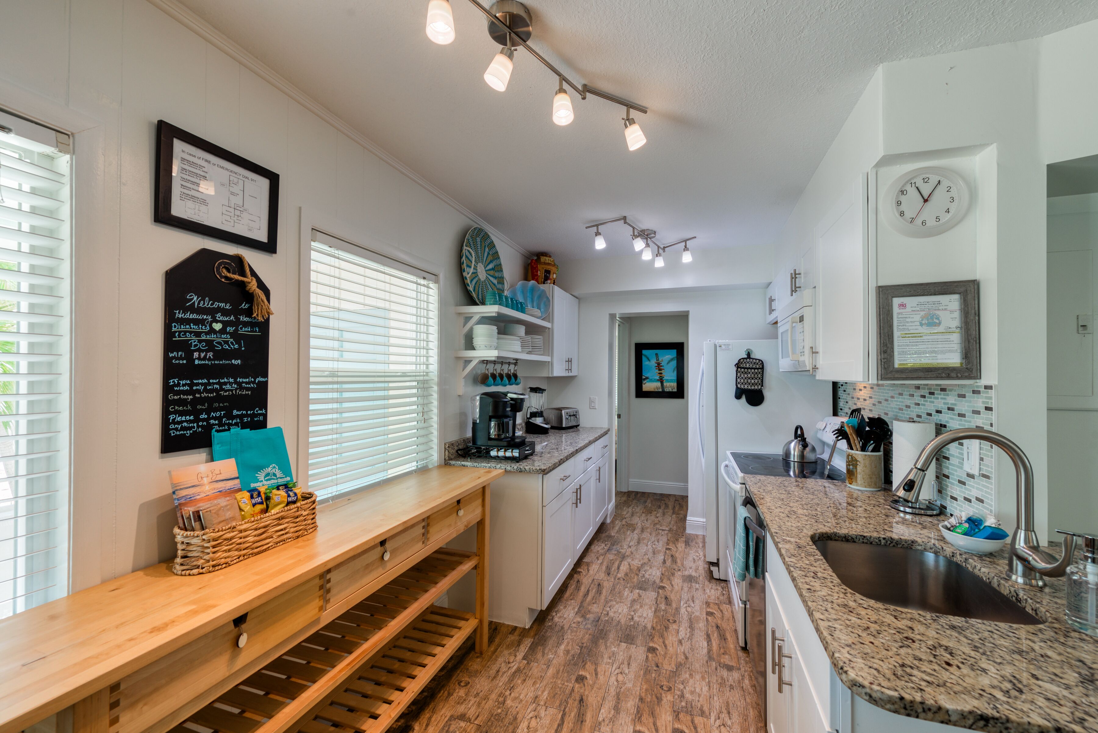 A modern kitchen with a wooden countertop, built-in appliances, and a chalkboard sign.