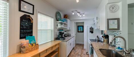 A modern kitchen with a wooden countertop, built-in appliances, and a chalkboard sign.