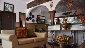 Ein Wohnzimmer mit einem beigen Sofa, einem Couchtisch und einer dekorativen Vase mit Blumen.