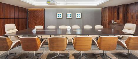 A conference room with a large table, six chairs, and a projector.