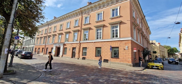 A multi-story building with a brick facade, large windows, and a corner entrance.