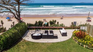 A patio with outdoor furniture overlooking a beach. - Mansão Pé na Areia de Geribá com 6Suítes (Búzios)