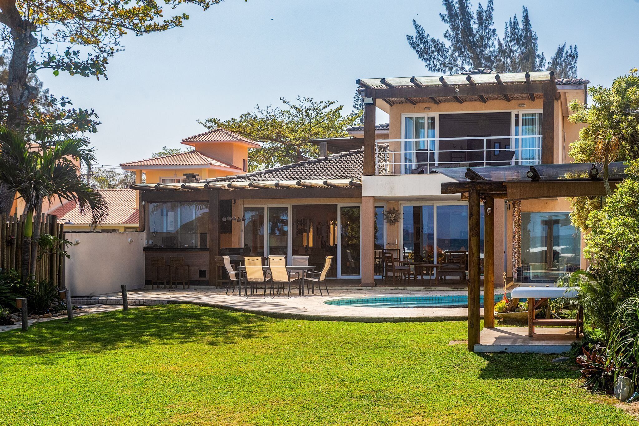 A modern two-story house with a swimming pool, outdoor seating area, and a covered patio.