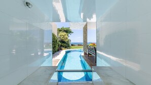 A swimming pool with a clear view of the sea and greenery. - Mansão Pé na Areia de Geribá com 6Suítes (Búzios)