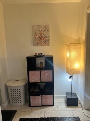 Cozy retreat with a black storage unit, floor lamp, and artwork on the wall.