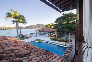 A rooftop pool with a view of the sea, palm trees, and a gazebo. - Cinematográfica Mansão Pé na Areia  (Búzios)