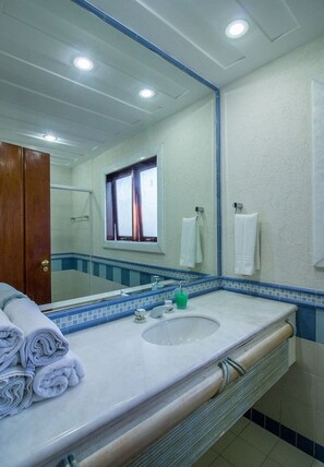 A bathroom with a large mirror, a sink, and a window. - Cinematográfica Mansão Pé na Areia  (Búzios)