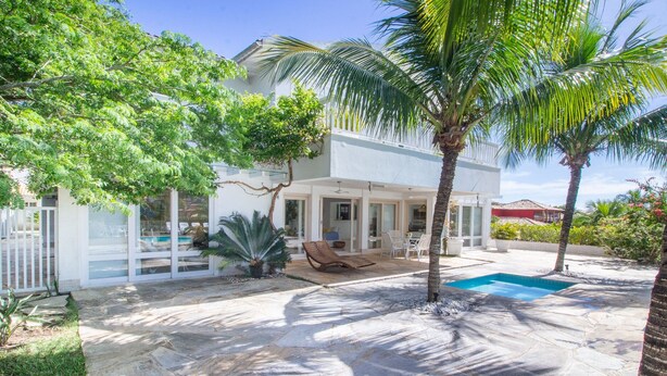A modern house with a swimming pool, patio furniture, and lush greenery. - Harmoniosa Mansão com 7 Suítes Ferradura (Búzios)
