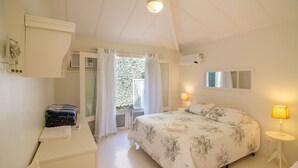 A bedroom with a bed, bedside lamps, a desk, and a window with curtains. - Harmoniosa Mansão com 7 Suítes Ferradura (Búzios)