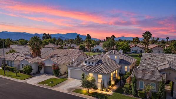 A residential area with houses featuring tiled roofs and well-maintained lawns.