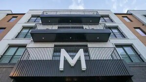 A multi-story building with a prominent 'M' logo on the facade. - Muse:5 minutes to broadway

 (Nashville)