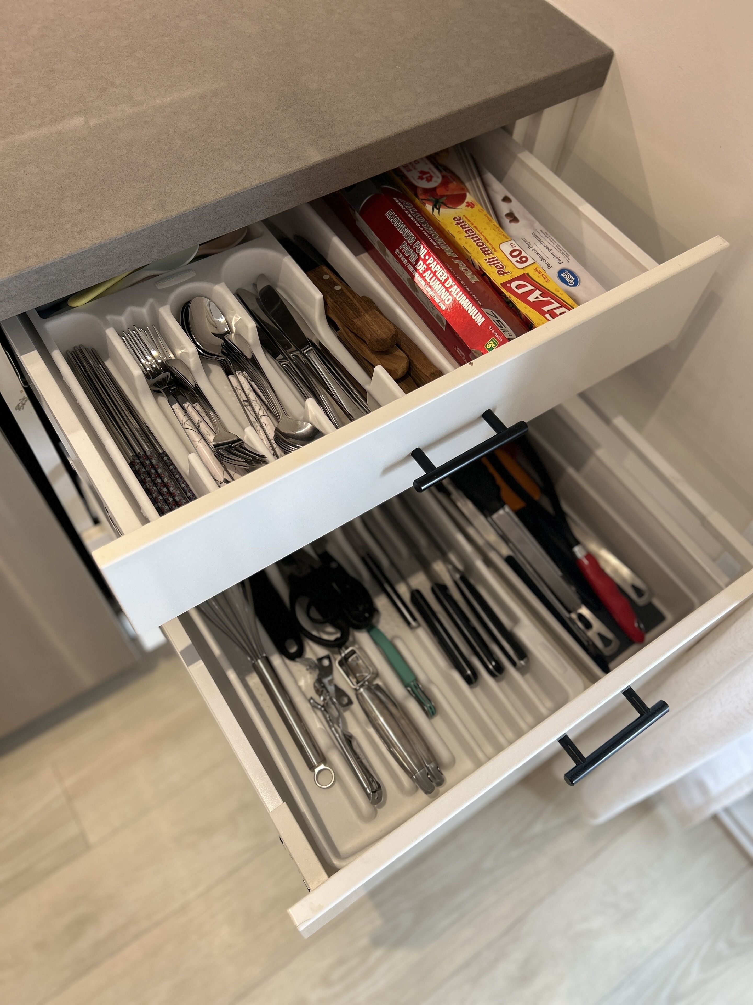 Un cassetto con utensili da cucina ordinati, tra cui forchette, coltelli e cucchiai.