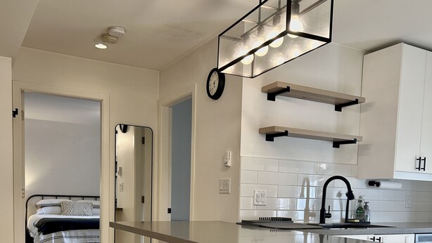A modern kitchen with a central island, bar stools, and a built-in oven.