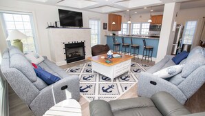 Una sala de estar moderna con sofás grises, una mesa de centro y una chimenea.