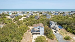 Un área residencial costera con casas, una playa y una vista despejada del océano.