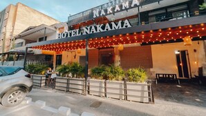 Hotel Nakama con fachada moderna, zona de estar al aire libre y entrada visible.