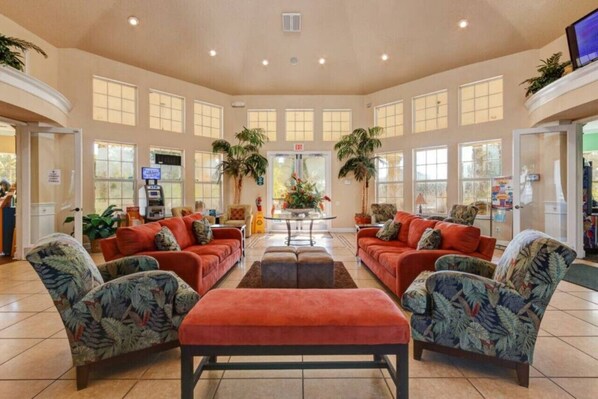 A spacious lobby with a central seating area, large windows, and a reception desk.