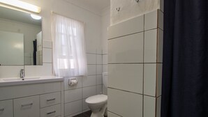 A bathroom with a white sink, mirror, and toilet. - Gundagai Motel (Gundagai)