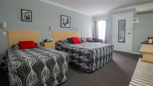 A hotel room with two beds, a desk, and a chair. - Gundagai Motel (Gundagai)