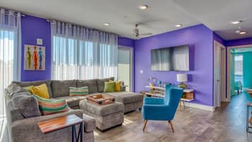 A living room with a sectional sofa, a blue armchair, and a wooden coffee table.