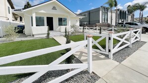 A residential area with a white house, a gated driveway, and a well-maintained lawn. - 4173-Newly renovated stylish home (San Diego)